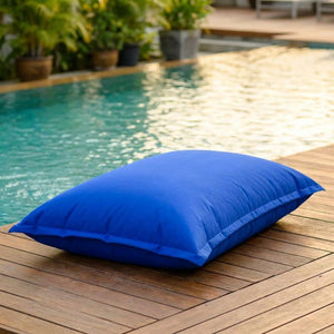 Pouf géant d'extérieur bleu roi au bord d'une piscine