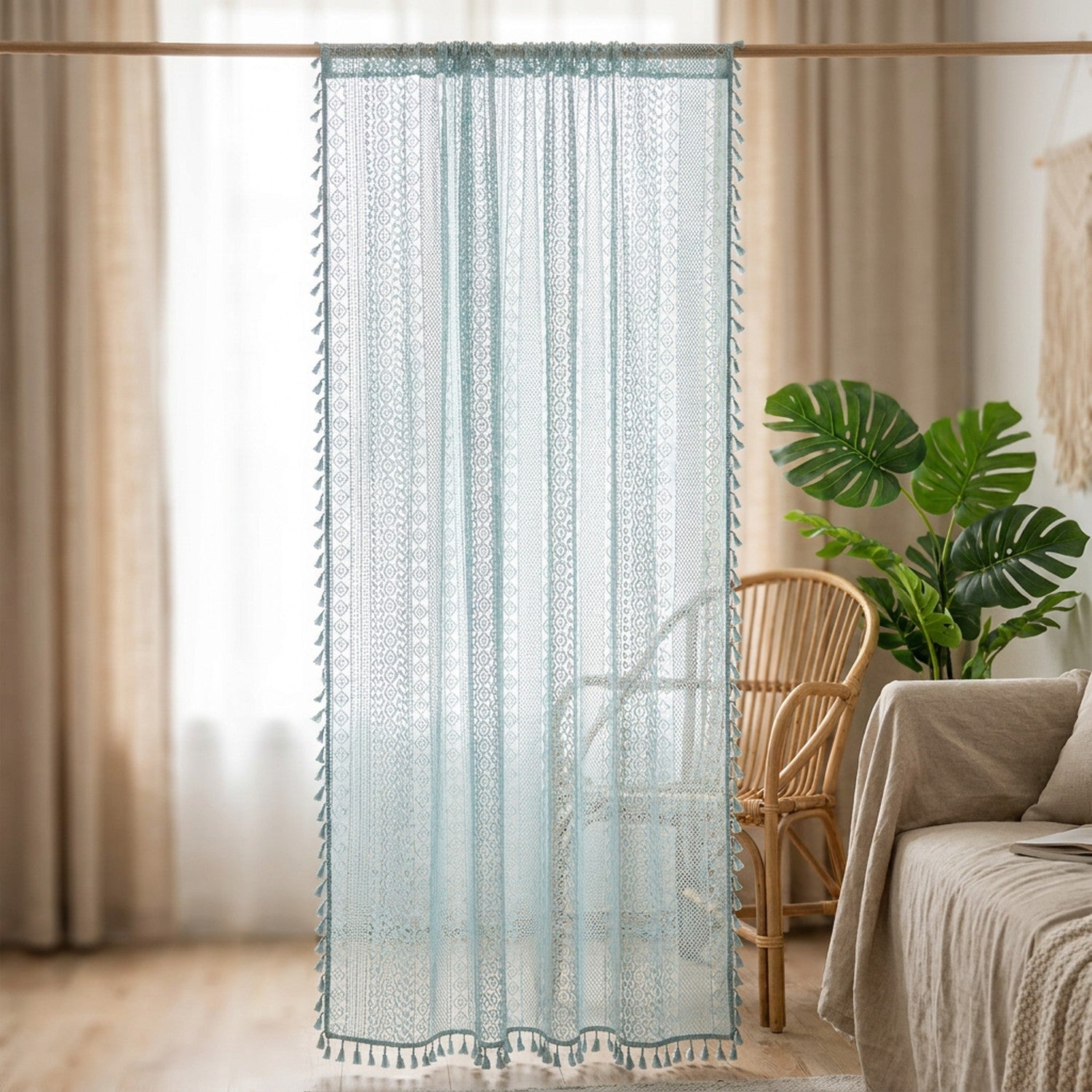Rideau voilage boho en dentelle au crochet bleu ciel à pompons suspendu à une fenêtre