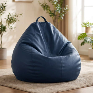 Pouf poire en simili cuir bleu marine posé au sol dans un intérieur cosy