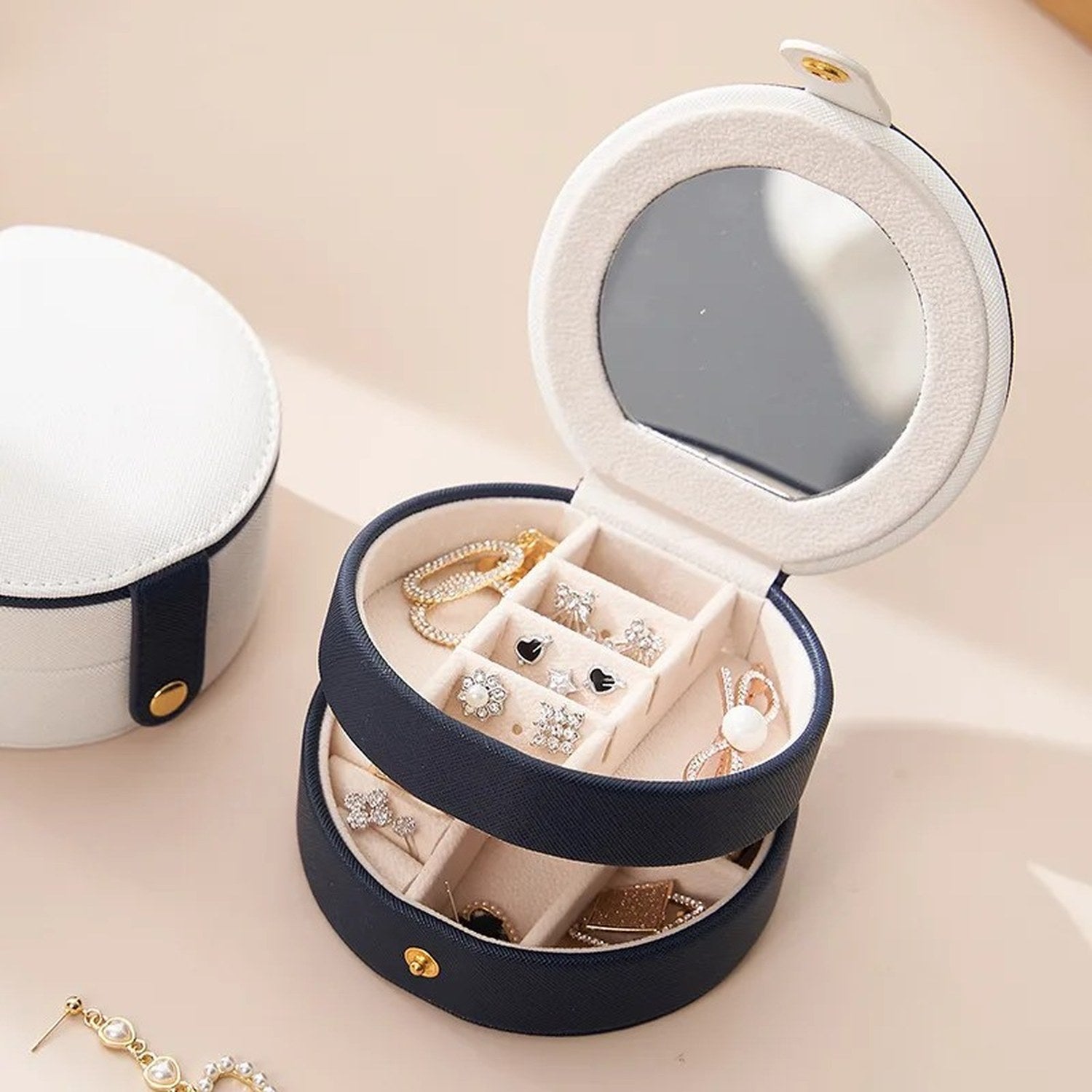 Boîte à bijoux ronde en cuir ouverte montrant les 2 niveaux et le miroir intégré