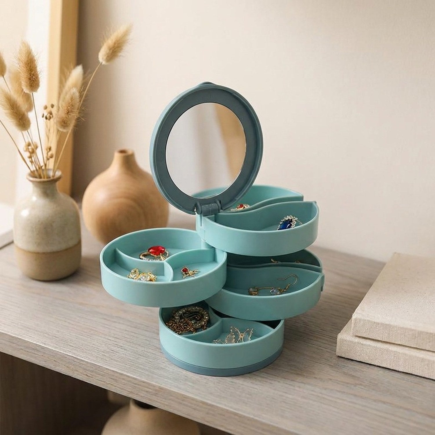 Boîte à bijoux rotative bleue ouverte sur étagère en bois avec vases