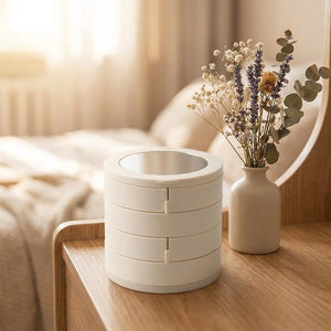 Boîte à bijoux femme rotative blanche à 4 niveaux avec miroir posée sur table en bois avec fleurs séchées