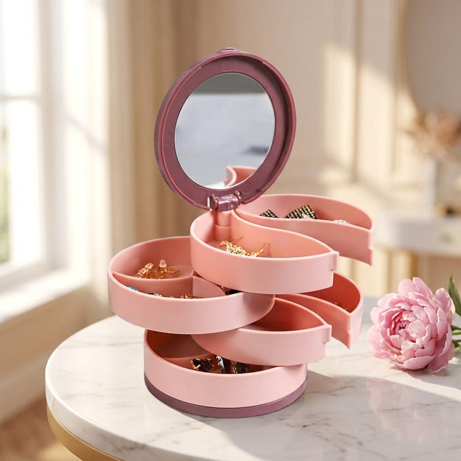 Boîte à bijoux rotative rose ouverte sur marbre avec pivoine