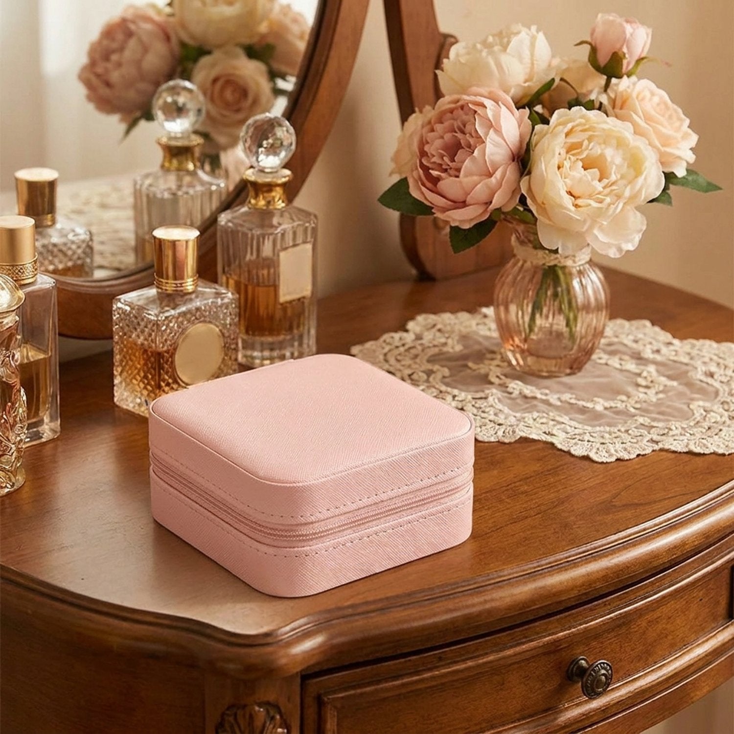 Boite bijoux voyage cuir rose sur coiffeuse parfums