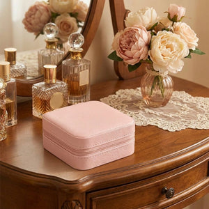 Boite bijoux voyage cuir rose sur coiffeuse parfums