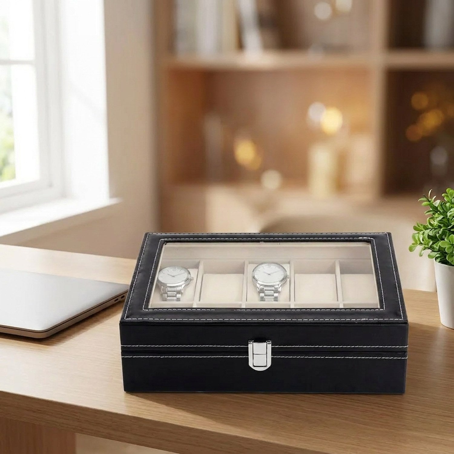 Boîte à bijoux et montres fermée sur un bureau à côté d'un ordinateur portable