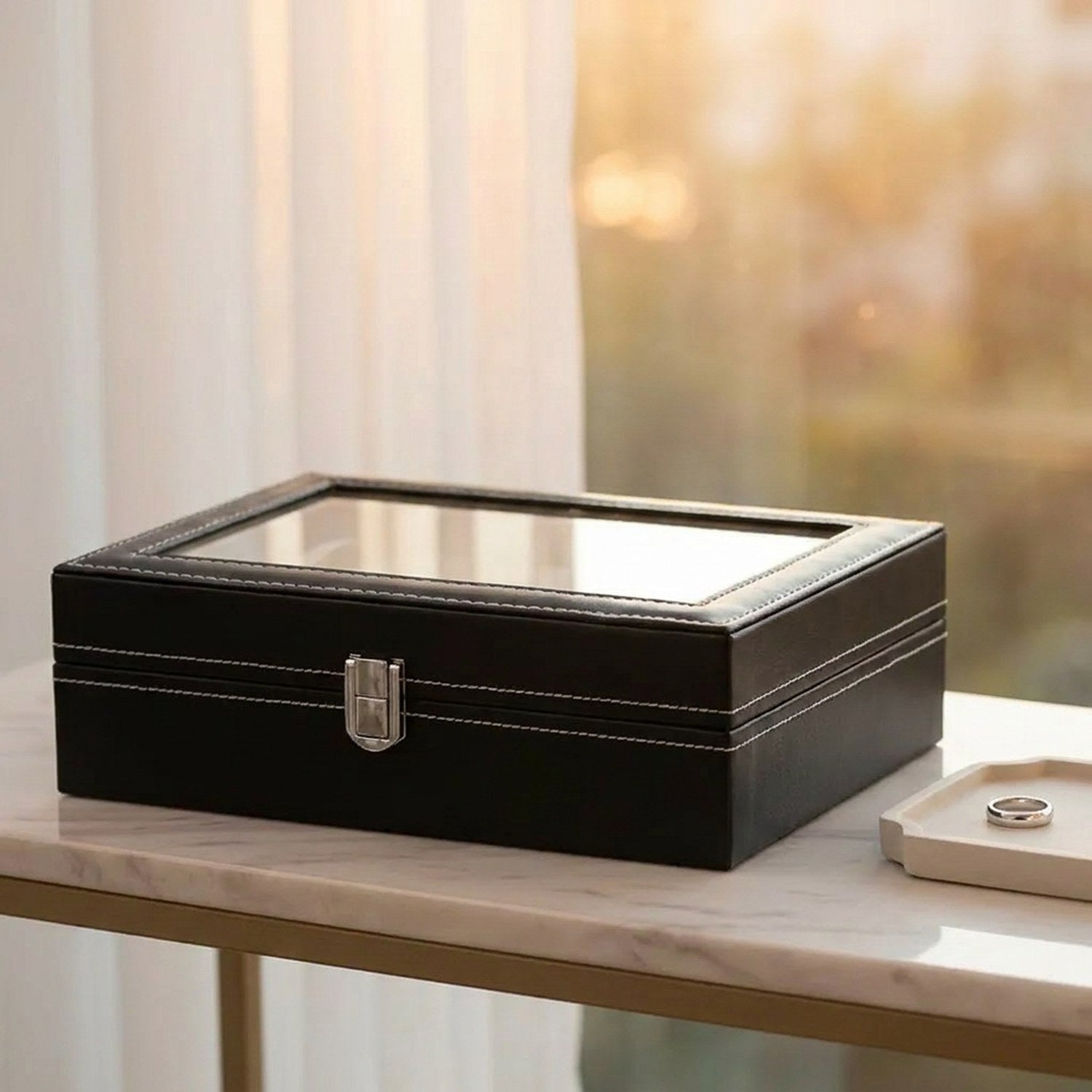 Boîte à montres au couvercle vitré posée sur une console en marbre