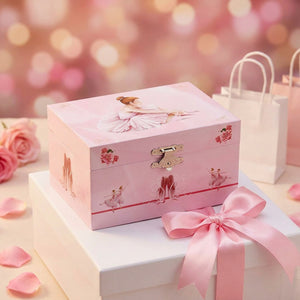Boîte à musique ballet rose présentée comme cadeau avec ruban satiné rose et pétales