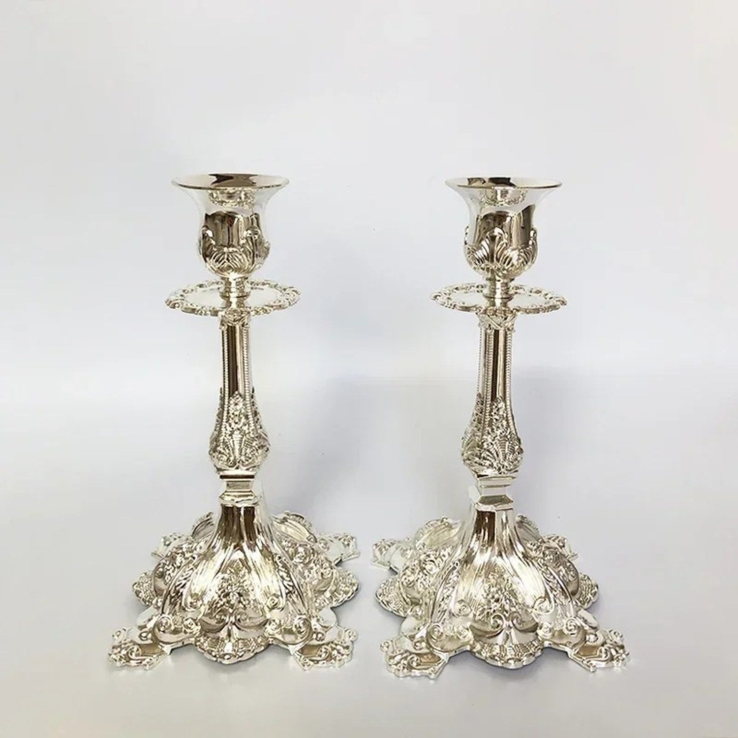 Lot de 4 bougeoirs dorés et argentés présentés sur fond décoration