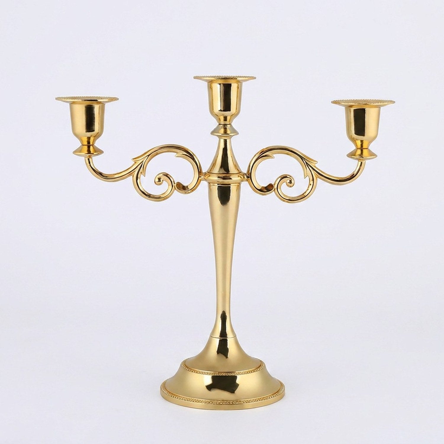 Bougeoir chandelier 3 branches sur surface dorée ambiance chaleureuse