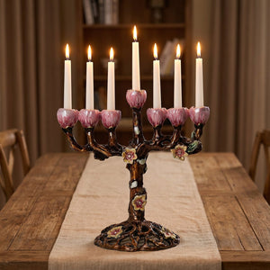 Bougeoir arbre floral à 7 branches en zinc émaillé avec bougies allumées sur table en bois