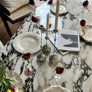 Bougeoir en métal argenté avec bougies allumées sur une table de fête