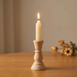 Petit bougeoir en bois brut 10,5 cm avec bougie conique allumée