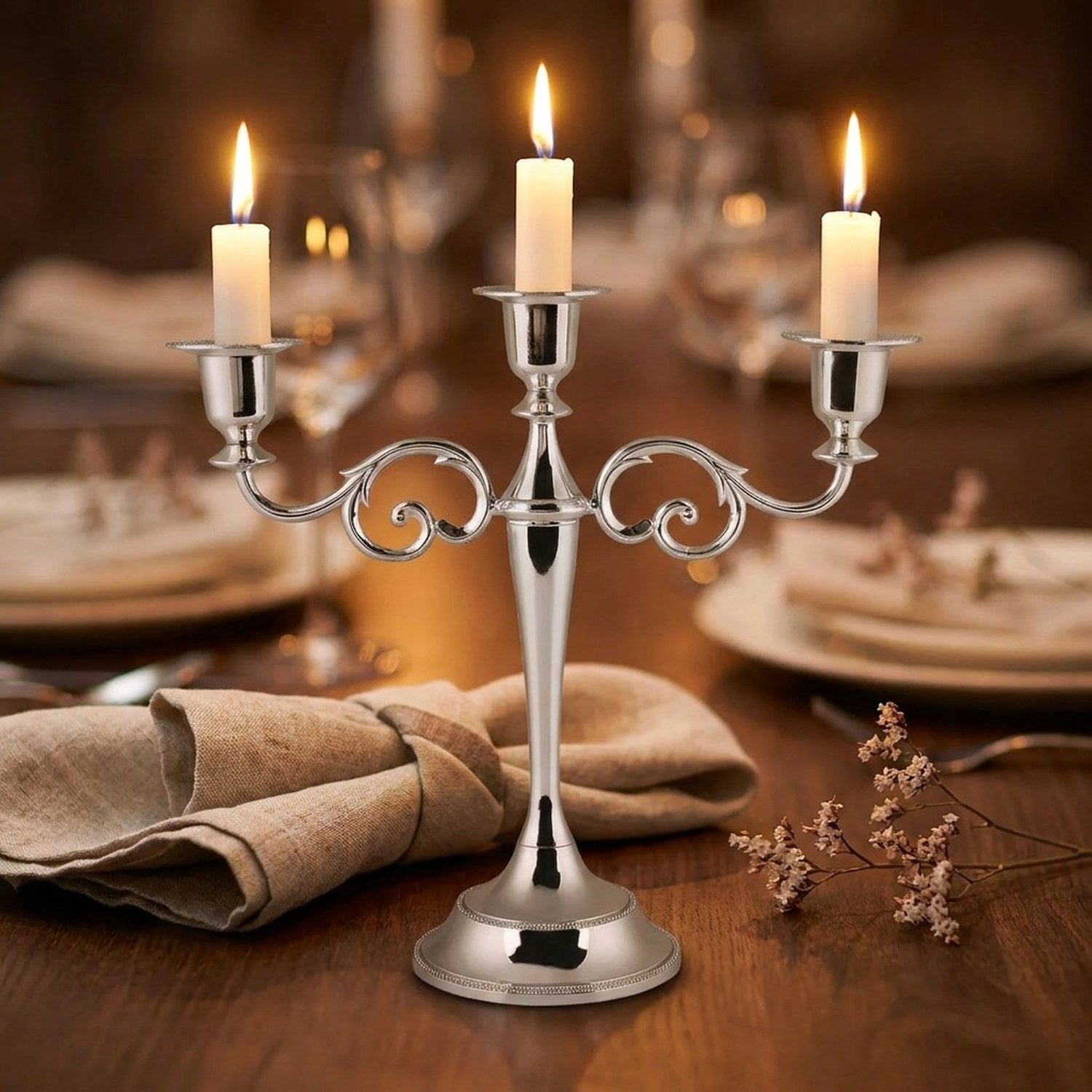 Bougeoir chandelier argent métal 3 branches avec bougies allumées sur table de dîner
