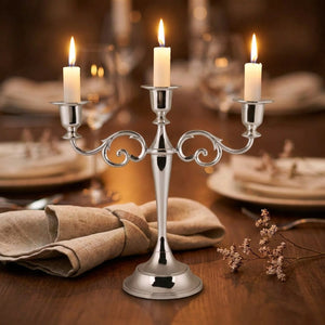 Bougeoir chandelier argent métal 3 branches avec bougies allumées sur table de dîner
