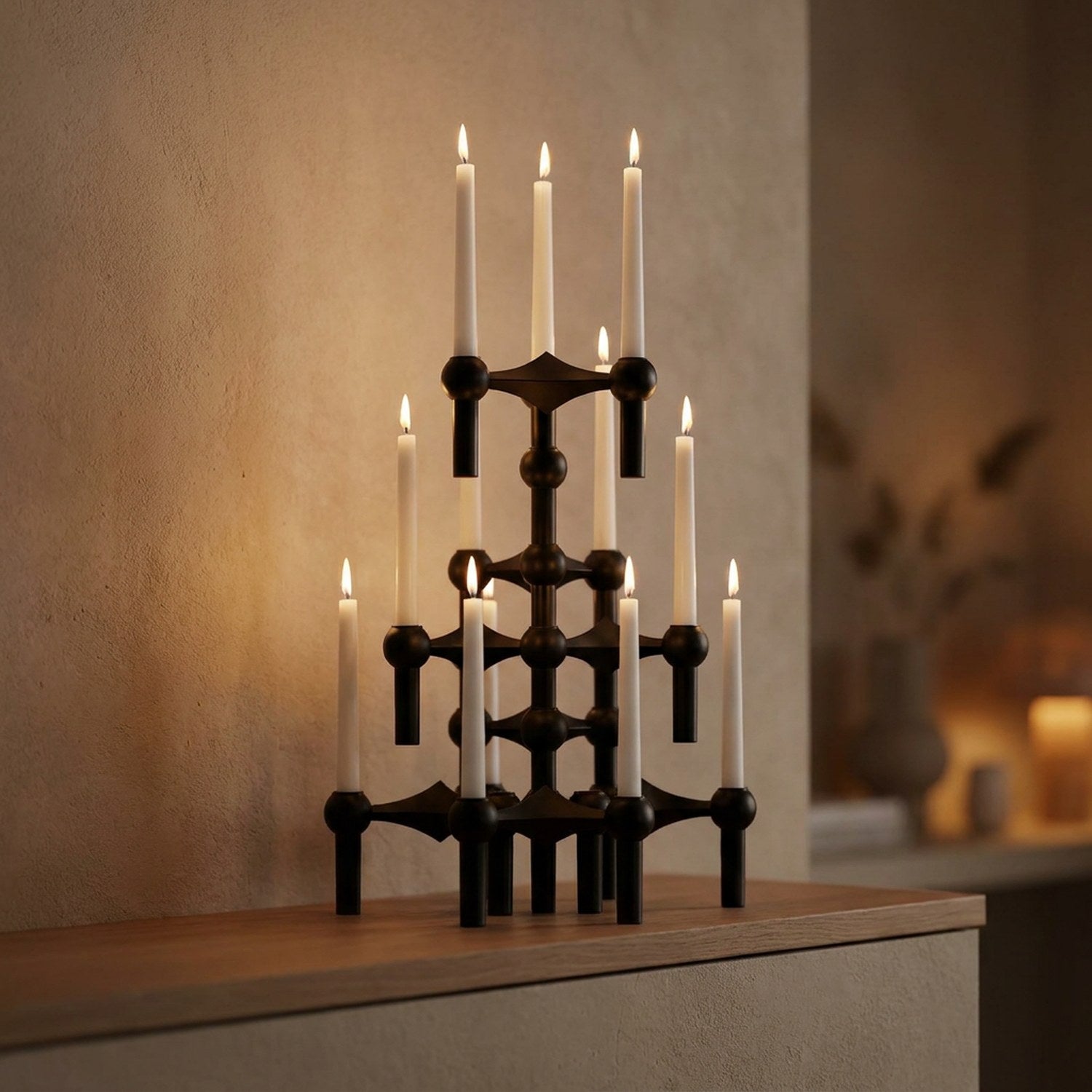 Bougeoirs moléculaires noirs empilés en chandelier avec bougies allumées sur une cheminée