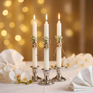 Bougies de baptême sur table de cérémonie avec orchidées et linge blanc