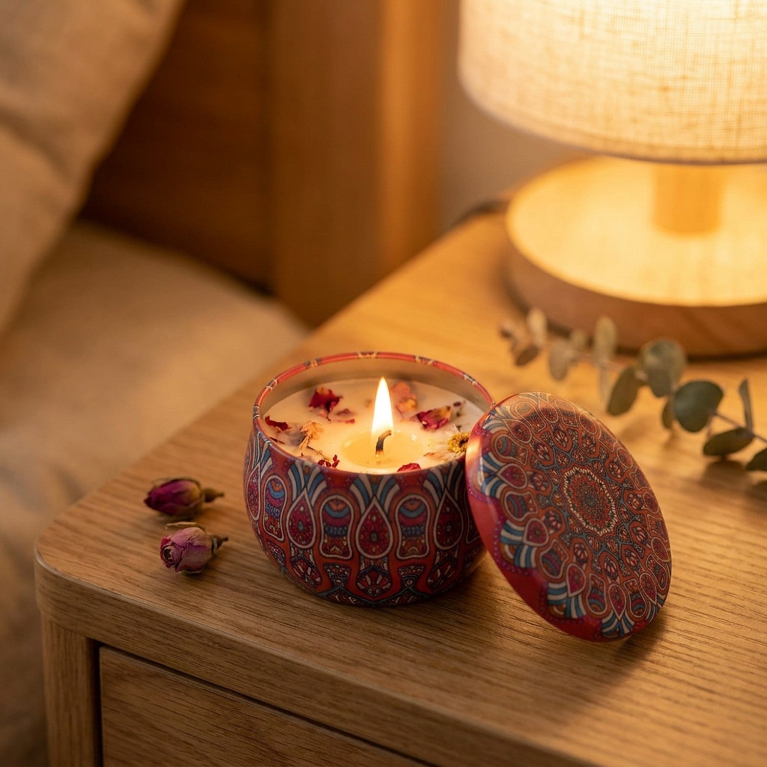 Bougie parfumée allumée sur une table de chevet en bois avec lampe douce et roses séchées