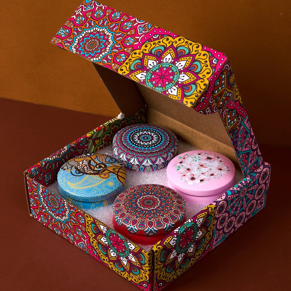 Détail de deux boîtes mandala avec bougie allumée et pétales