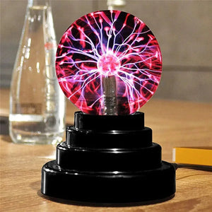 Boule plasma allumée posée sur une table à côté d'une bouteille d'eau