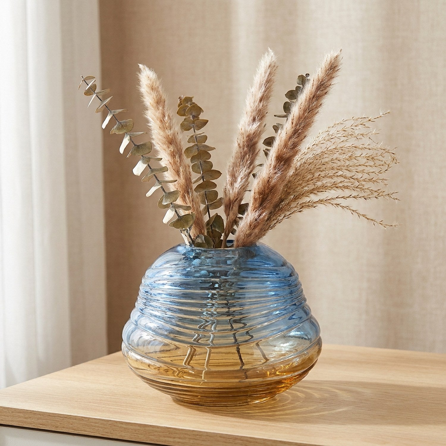 Vase boule en verre dégradé bleu ambré avec branches séchées