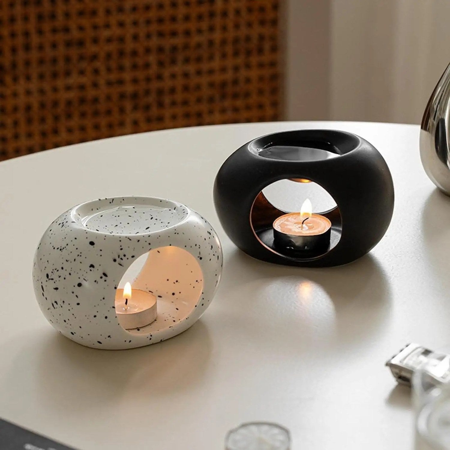 Brûle-parfums céramique moucheté et noir sur table ronde blanche