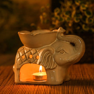 Brûle-parfum céramique éléphant avec bougie chauffe-plat allumée dans une ambiance chaleureuse