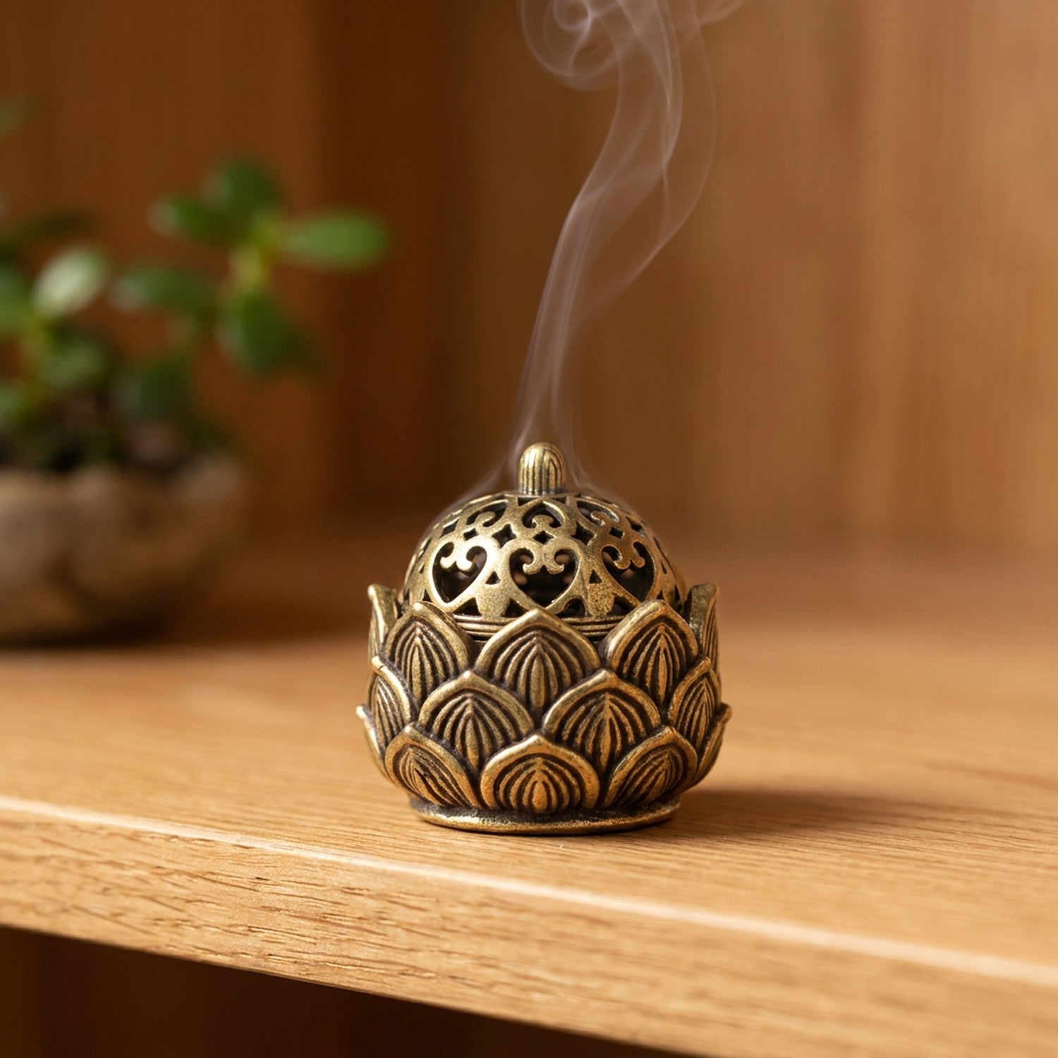 Brûleur d'encens bouddhiste lotus en laiton doré sur une étagère en bois avec une plante verte