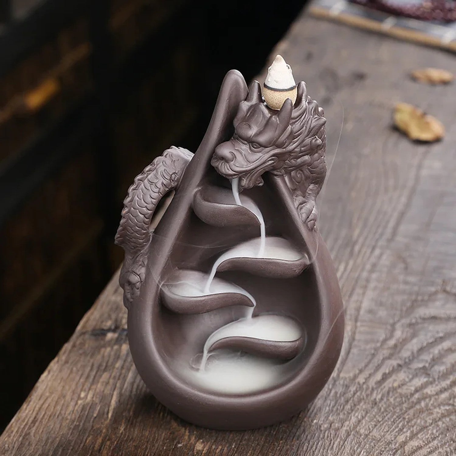Porte-encens dragon avec fumée en cascade sur surface en bois