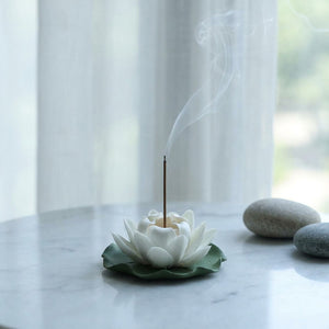 Brûleur d'encens lotus céramique sur marbre voilage blanc ambiance méditation zen