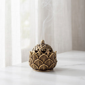 Brûleur d'encens lotus laiton sur surface marbre fenêtre voilage blanc ambiance zen