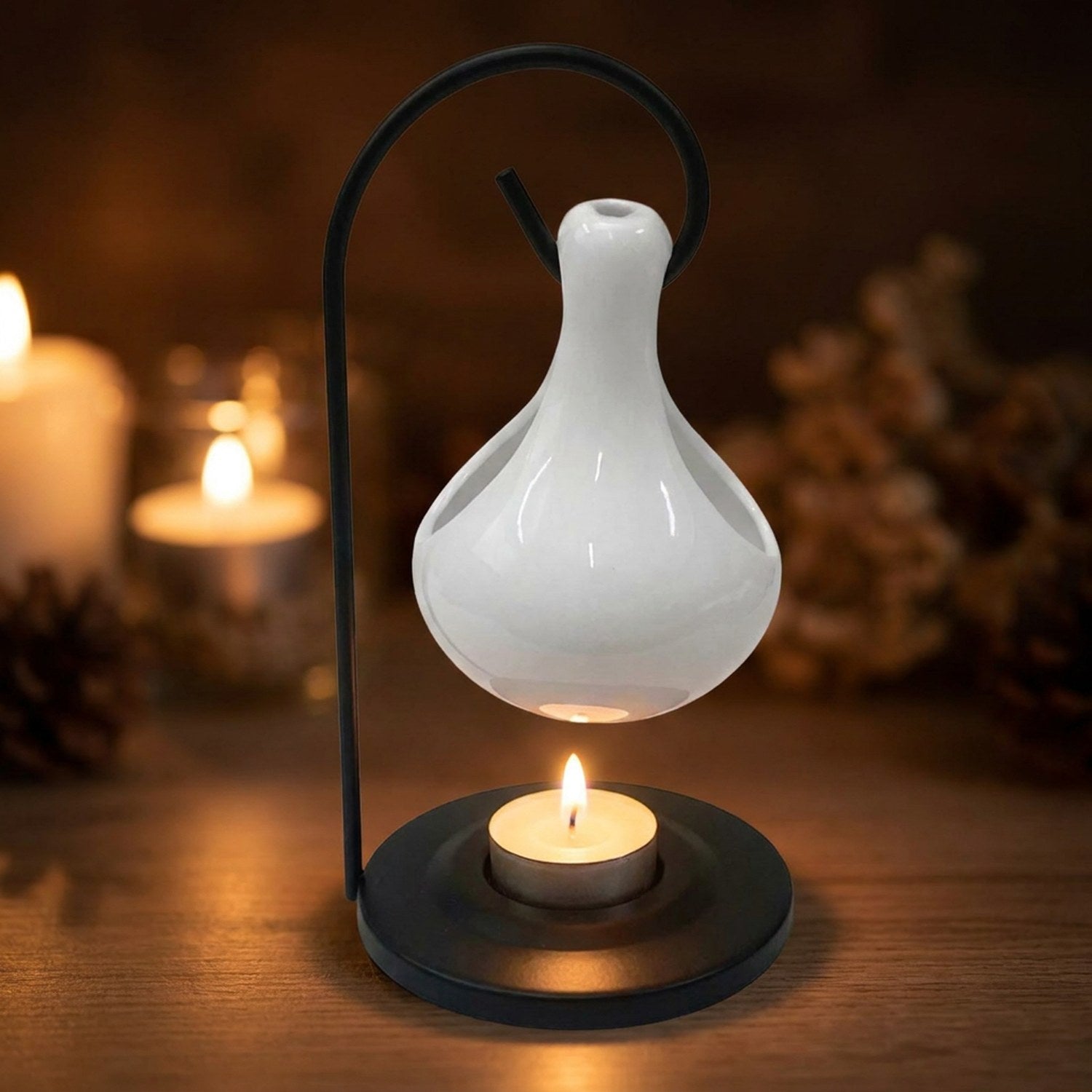 Gros plan sur le brûle-parfum en céramique blanche et la flamme de la bougie