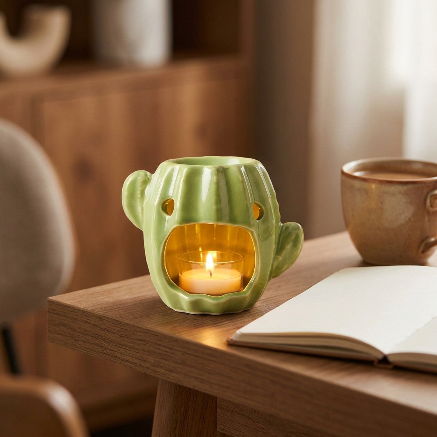 Brûle-parfum cactus en céramique allumé sur un bureau en bois