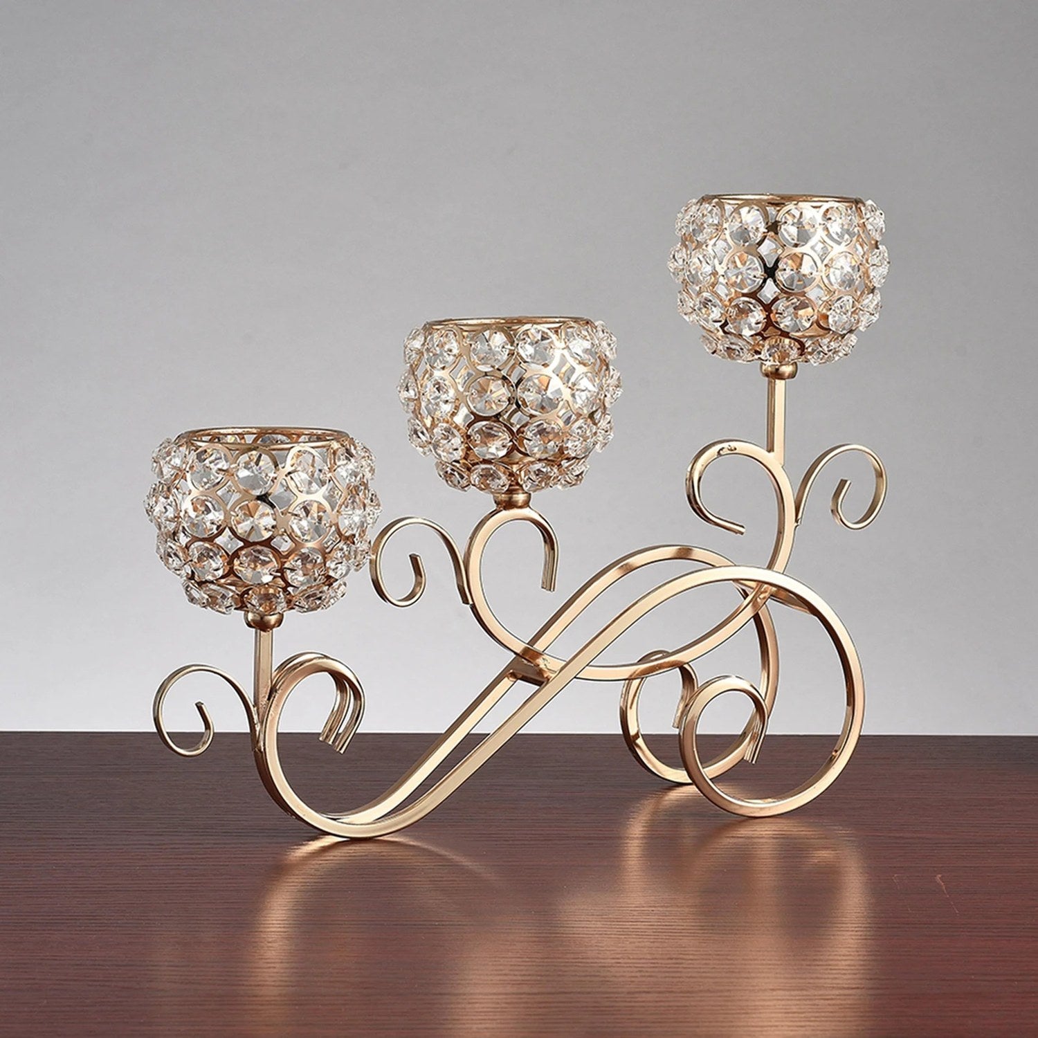 Chandelier 3 branches doré posé sur une table en bois vue studio