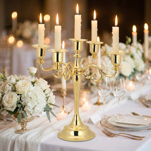 Chandelier doré à 5 branches sur une table de mariage fleurie avec bougies allumées