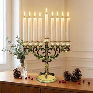 Chandelier à 9 branches en métal doré posé sur un buffet en bois avec eucalyptus et pommes de pin