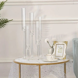 Chandelier acrylique transparent 5 bras posé sur une table décorée avec nappe dorée
