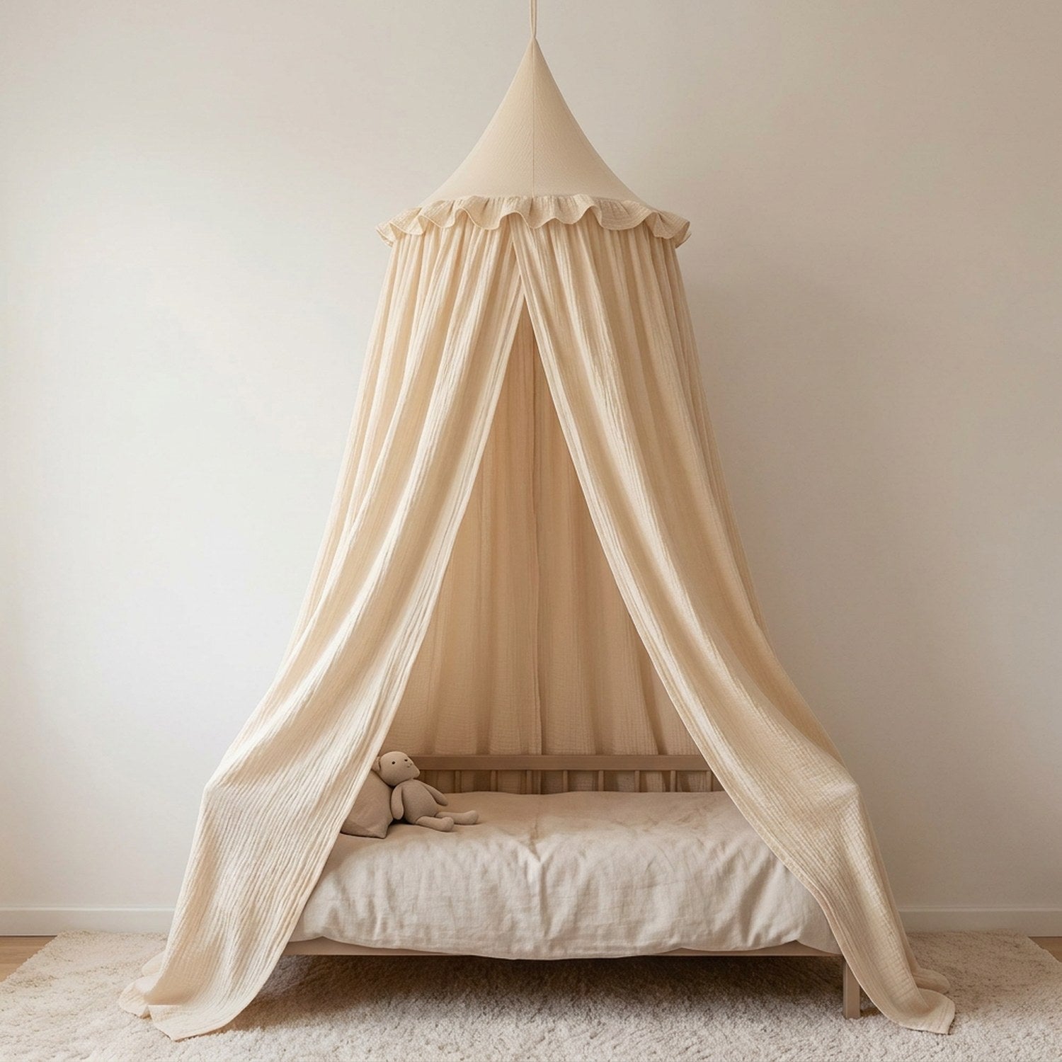Ciel de lit en mousseline de coton beige suspendu au-dessus d'un lit d'enfant