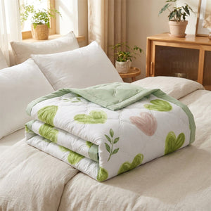 Couvre-lit matelassé d'été motif cœurs verts plié sur un lit