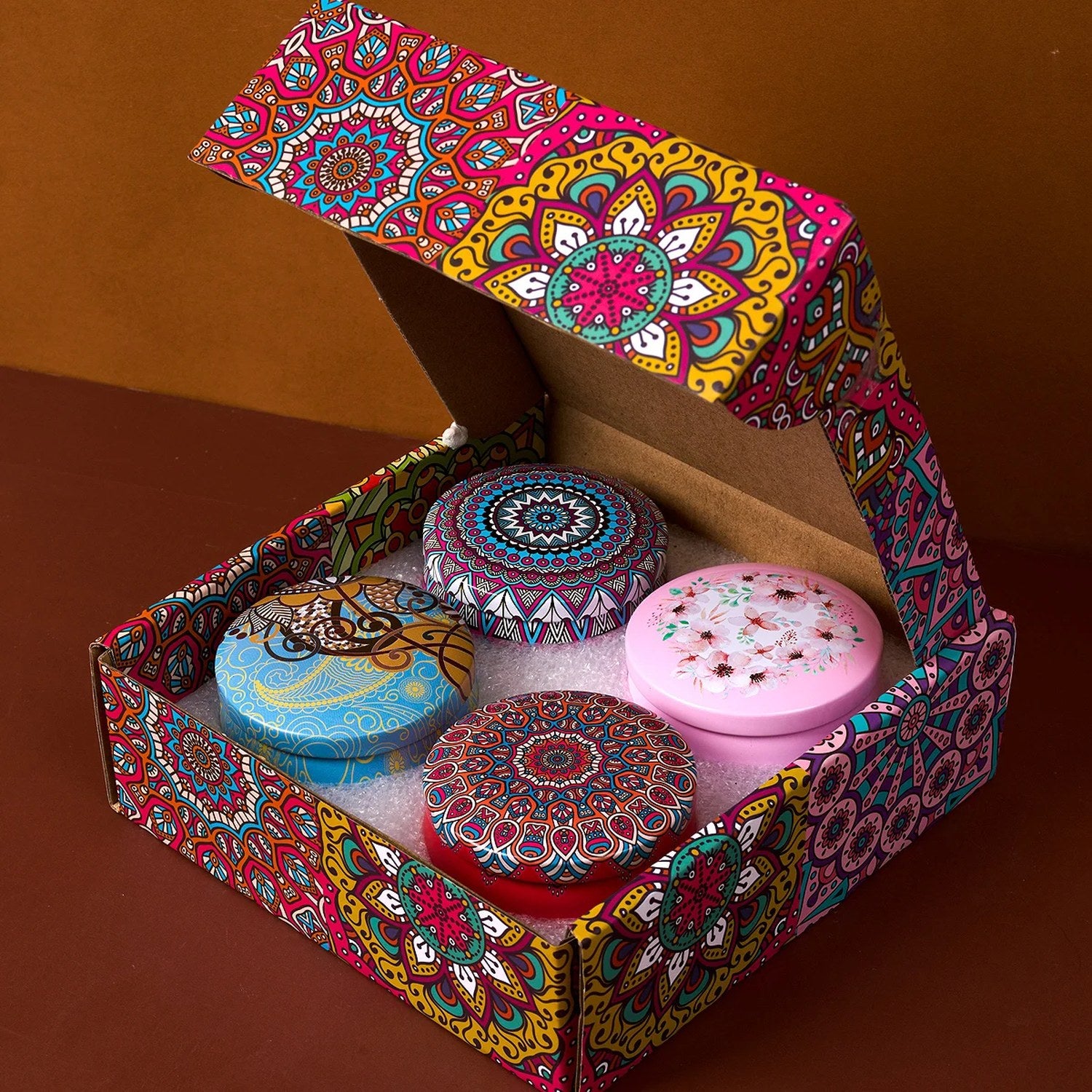 Coffret cadeau ouvert avec 4 bougies parfumées en boîtes métalliques mandala