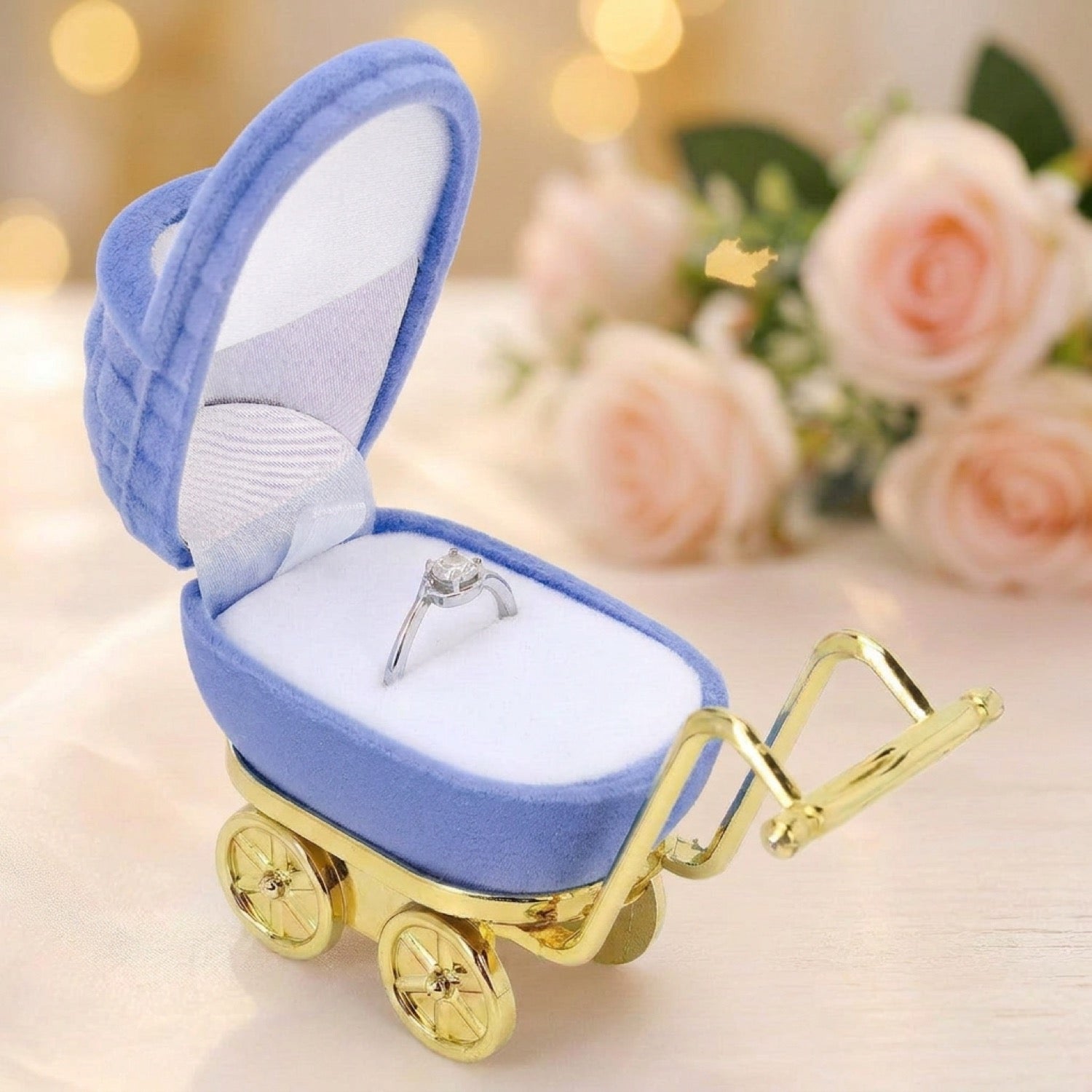 Coffret à bijoux landau bleu pervenche en velours avec bague solitaire sur fond clair et roses