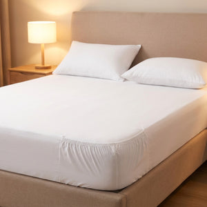 drap-housse en coton blanc posé sur un lit dans une chambre lumineuse