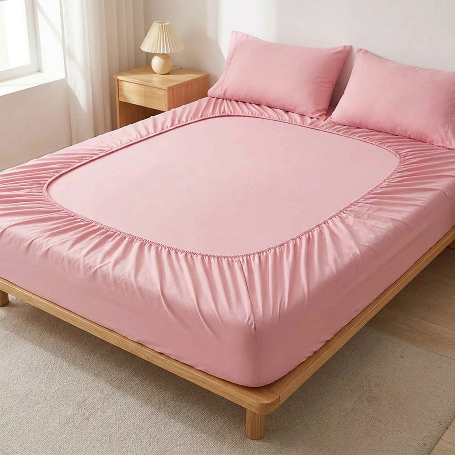 drap-housse en coton rose sur un lit