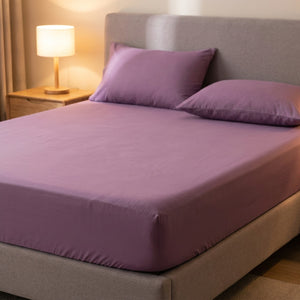 drap-housse en coton violet sur un lit