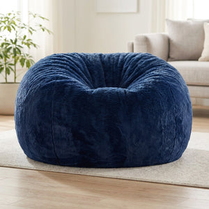 Pouf géant en fausse fourrure bleu marine posé au sol dans un salon