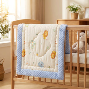 Couette bébé pliée sur le rebord d'un berceau dans une chambre douce avec peluche