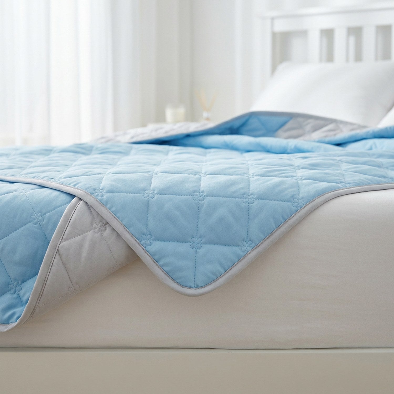 Détail de la couette d'été réversible bleue et grise au matelassage fleur délicat