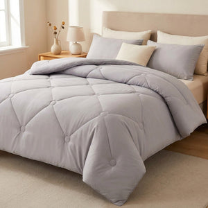 Couette en laine épaisse coloris gris posée sur un lit fait