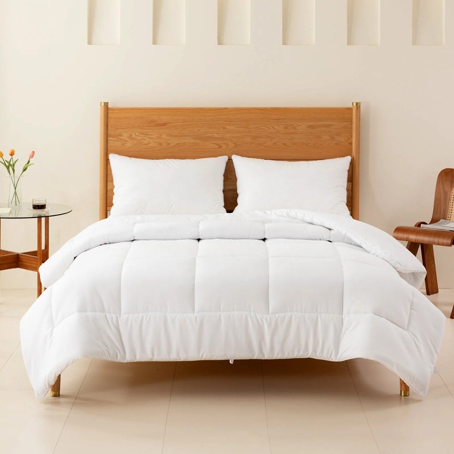 Lit fait avec couette blanche et oreillers dans une chambre épurée