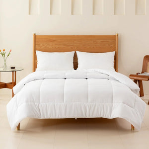 Lit fait avec couette blanche et oreillers dans une chambre épurée